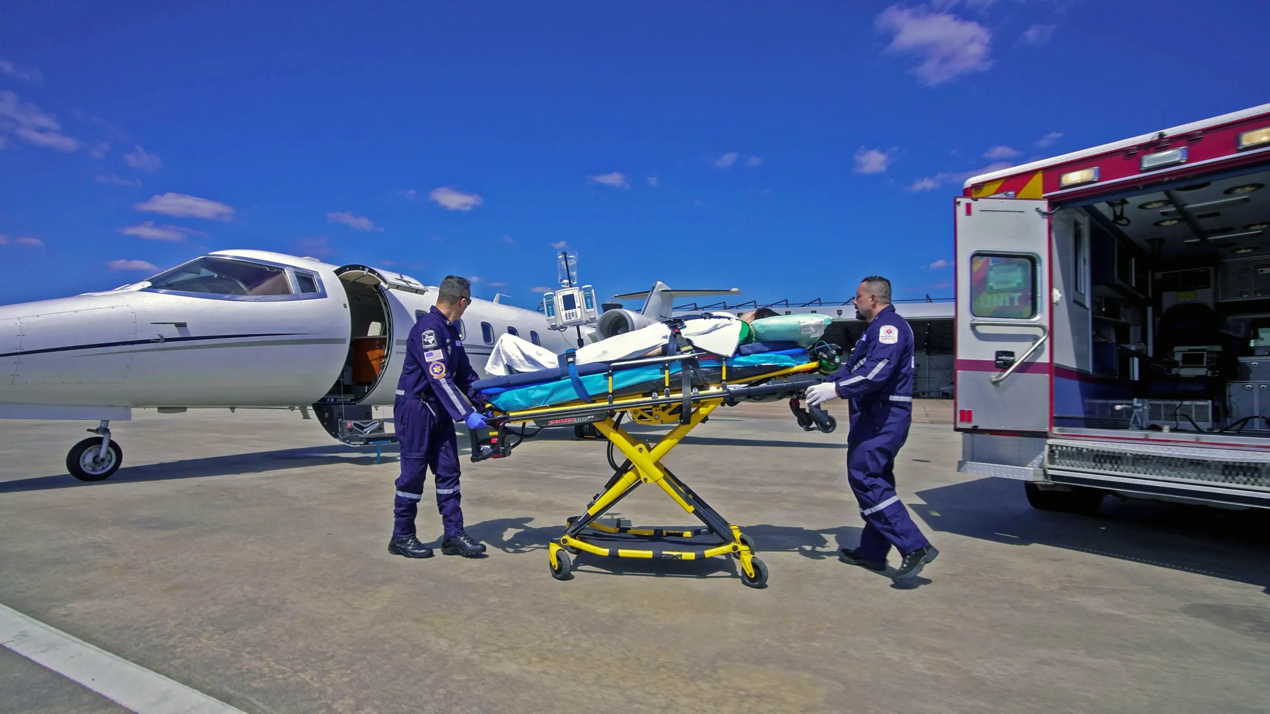Fixed-wing air ambulance coordination team monitoring a patient transfer